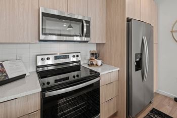 a kitchen with a stove and a refrigerator  at Altis Grand Suncoast Apartments, Florida
